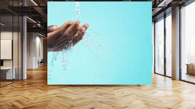 Water, black man and cleaning hands with mockup space, wash face and skincare isolated on blue background. Healthy skin, clean cosmetics and grooming, hygiene and beauty sustainability in studio Wall mural