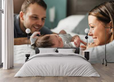 A beautiful couple with newborn Baby on bed. Wall mural