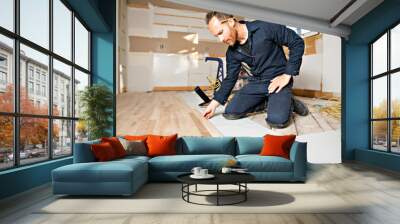 A Male Worker install wood floor on a house Wall mural