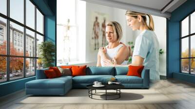 a modern rehabilitation physiotherapy worker with woman client Wall mural