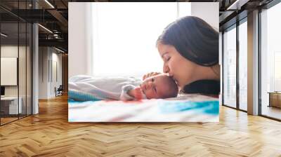 A Portrait of a beautiful mother with her newborn baby in the bedroom Wall mural