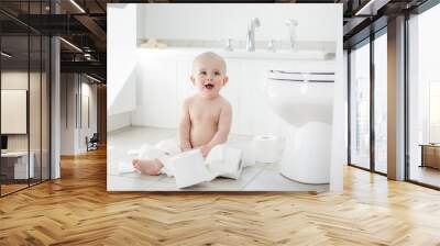 Adorable baby boy playing with toilet paper Wall mural