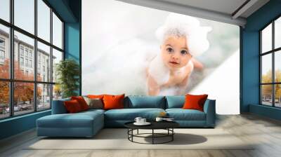 Baby boy bathes in a bath with foam and soap bubbles Wall mural