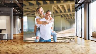 Beautiful couple having fun outdoors on industrial background Wall mural