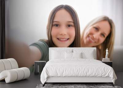 Beautiful pre teen girl with mother on the living room Wall mural