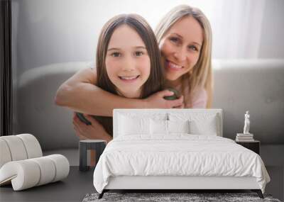 Beautiful pre teen girl with mother on the living room Wall mural