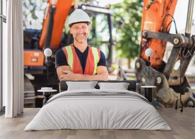 caucasian engineer with white helmet at work and having a mechanical shovel on the back Wall mural