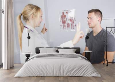 Doctor examining her patient in medical office Wall mural