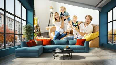 Family having fun on sofa. Wall mural