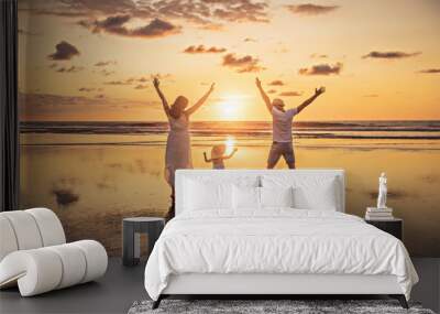 Family on the beach concept, Caucasian family playing and carrying his daughter on the tropical beach in sunset. Wall mural