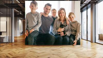 family with French Bulldog Puppy on the sofa Wall mural