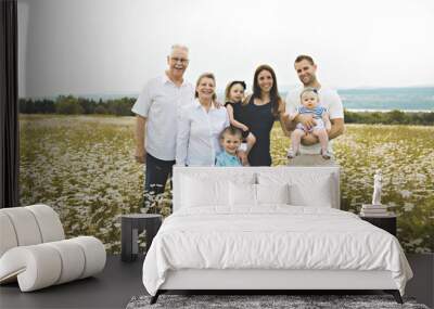 Family with grandparent spending time with little child during the sunset. Wall mural