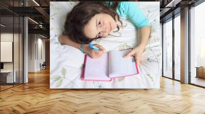 Girl writing diary in bed Wall mural