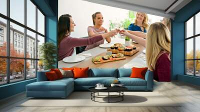 Group of attractive mature people eating sushi at home Wall mural