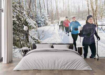 Group of friends enjoying jogging in the snow in winter Wall mural