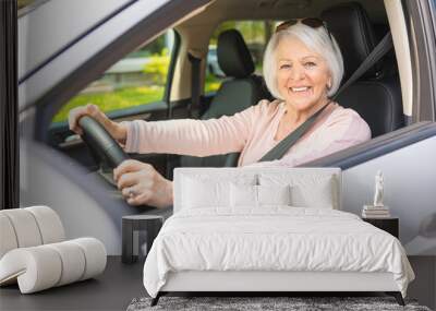 Happy and smiling senior woman in white car Wall mural