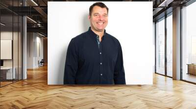 Head and shoulders portrait of a bearded middle-aged man looking thoughtfully at the camera over a white studio background with copy space Wall mural