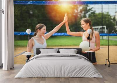 High five, two women play beach volleyball in summer Wall mural