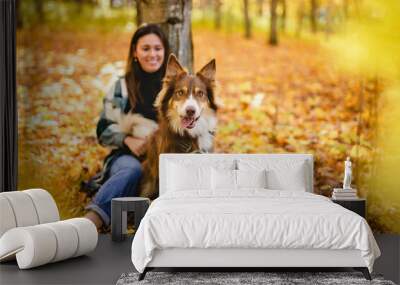 Loving woman with her shepherd Australian on fall season Wall mural