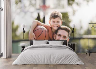 man and young boy playing basketball on a court, teaching little player and spending time outdoors Wall mural