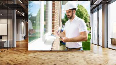 man with a white hard hat holding a clipboard, inspect house Wall mural