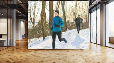 mature couple in the winter running together in nature Wall mural