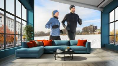 mature couple in the winter running together in nature Wall mural