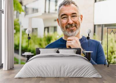 Mature man walking outside in city background Wall mural