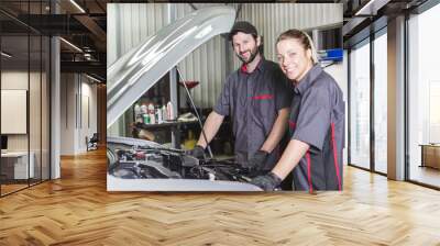 Mechanic woman and men working team in his shop Wall mural