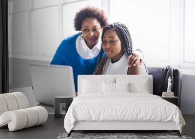 Mother And Teenage Daughter Looking At Laptop Together Wall mural