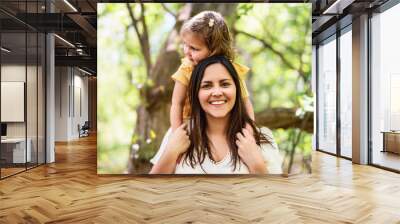 mother with his daughter having fun outside in forest Wall mural