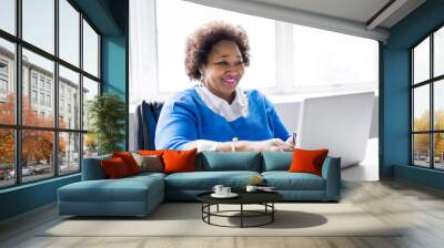 Portrait of cheerful business African-American working on laptop Wall mural