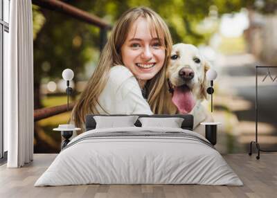 Portrait of teenage girl having fun outside with golden retriever Wall mural