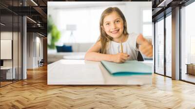 Pretty little girl enjoys learning and doing some homework Wall mural