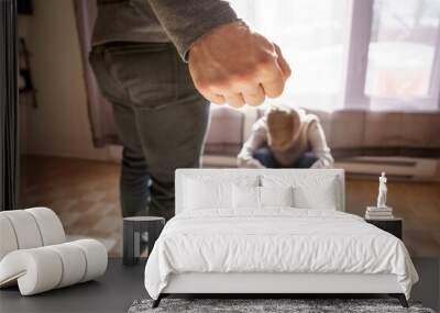 Sad child boy sit on the floor with father in front of him with hard look and close fist Wall mural