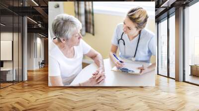 Senior woman with her caregiver at home Wall mural