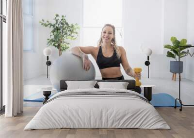 smiling woman with exercise ball in gym Wall mural