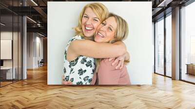 Studio shot of two happy girlfriends over white background Wall mural