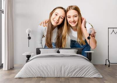 Two Young pre teen best friend girl on studio white Wall mural