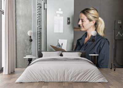 Woman Technician servicing at work on electric room Wall mural