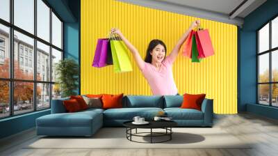 Asian women hold a shopping bag in a colorful yellow background,summer sale concept Wall mural