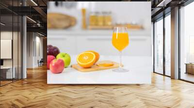 Orange juice is placed on a white table, orange juice, bright colors placed on the table and the atmosphere in the kitchen is clean white. Wall mural