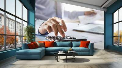 accountant working on desk using calculator for calculate finance report in office Wall mural