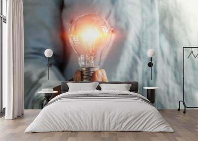 businessman hand holding lightbulb. idea Alternative energy concept saving electricity Wall mural