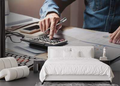 businessman working in office with using a calculator to calculate the numbers finance accounting concept Wall mural