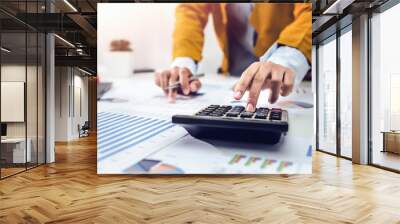 businesswoman working on desk using calculator and laptop analyzing finance accounting Wall mural