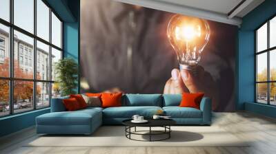 hand holding light bulb. idea concept with innovation and inspiration Wall mural