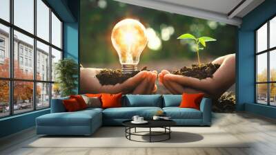 hand holding lightbulb with small tree and sunshine. concept energy power in nature Wall mural