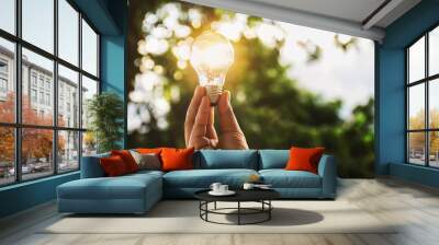 idea solar energy in nature, hand holding light bulb concept Wall mural