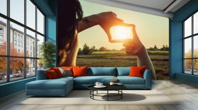 woman hand framing view distant over sunset. business concept Wall mural